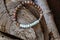 Stone yoga bracelet with metal feather pendant on wooden background