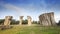 A Stonehenge of Thailand under clear blue sky in front of green grass location