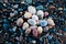 Stones of different shades and different oval shapes lie on the stony shore of a large and cold lake.