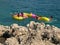 Stones, families on beach toys in sea