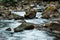 Stones with green mold near flowing brook