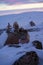 stones are heaped in the snow near the road at dawn