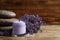 Stones, jar of cream and lavender flowers on wooden table. Space for text