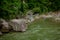 Stones and mountain river with small waterfall, blurred background, the flow of a mountain river