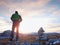 Stones pyramid on Alpine gravel mountain summit. Daybreak horizon above blue mist in valley.