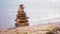 Stones pyramid on sand symbolizing zen, harmony, balance. Ocean in the background. Soft focus