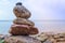 Stones pyramid on the seashore. Sunset on pebble beach. Balanced life, relax