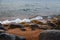 Stones on the sea beach. Pasture winter day. Clear water and sand. Kyrgyzstan, Issyk-Kul Lake