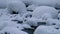 Stones with snow caps in the water of frozen river Pescherka in winter