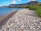 The stoney shores of Nikolaiika Beach on the Corinthian Gulf in Greece