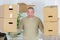 Stong mature man carrying boxes during moving