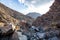 Stony, dry riverbed wadi with remains of raw ore of copper, green stones and rocks, Copper Hike Trail, Hatta, UAE