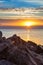 Stony shore against the sea, sunset, clouds