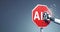 stop AI. Red road sign being crushed by a robot hand. Illustrative cartoon style. Gray background.