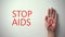 Stop AIDS inscription, hand with red ribbon, awareness and prevention campaign