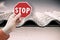 Stop asbestos material - concept with hand holding a stop road sign against a dangerous asbestos roof panel