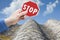 Stop asbestos material - concept with hand holding a stop road sign against a dangerous asbestos roof panel