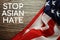 Stop Asian Hate text with USA flag on wooden background