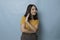 Stop. Concerned Asian woman showing refusal sign, saying no, raise awareness, standing over blue background