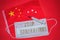 STOP CORONAVIRUS is wording on a protective medical mask. China`s flag, tablets and syringe on a red background