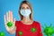 Stop Covid-19 outbreak. Woman wearing medical mask surrounded by virus on blue background