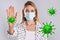 Stop Covid-19 outbreak. Woman wearing medical mask surrounded by virus on light background