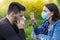 Stop the Covid-19 pandemic, Girl with protective mask and sneezing boy in the floral park