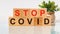 Stop covid word written on wood block. text on wooden table for your desing, Health and medicine concept. Healthcare concept