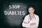 STOP DIABETES prevention concept doctor writing text on black chalkboard background for awareness. Asian woman