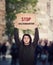 Stop discrimination, street manifestation protest. Man with hands outstretched holding a cardboard banner with warning message.