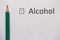 Stop drinking. word ALCOHOL is written on white paper with cross and pencil.