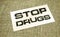 Stop drugs words on card on burlap canvas. Addictions healthcare concept