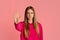 Stop gesture. Strict teenage girl in pink hoodie raises hand