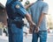 Stop, handcuffs and hands of police man with criminal in city for justice, crime or corruption. Illegal, arrest and law