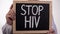 Stop HIV text on blackboard in doctor hands, AIDS awareness, disease prevention