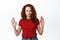 Stop I said no. Serious and confident redhead girl showing block taboo gesture, raising hands to prohibit or reject