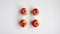 Stop motion animation of a flat lay top view of four red autumn apples on midline that alternately disappear on white background.