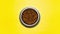 Stop motion animation photography. Top view of dry food for cats disappear from round steel bowl on yellow background.