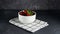 Stop Motion Animation. Ripe juicy large strawberries appear in a white plate in a low key