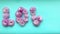 Stop motion animation the word love of pink chrysanthemum flowers appears and then disappears on a delicate blue background.