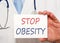 Stop Obesity - doctor holding white sign with text