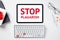 Stop plagiarism concept. Office desk table with keyboard, paper notebooks, glasses, tablet with message STOP PLAGIARISM on screen