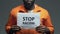 Stop racism phrase on cardboard in hands of black prisoner, discrimination