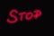Stop red neon glowing text sign handwriting