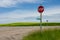 Stop sign and country roads and vibrant yellow canola fields in rural Manitoba, Canada