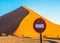 Stop sign in front of sand dune in Sossusvlei, Namib-Naukluft Na