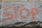 Stop sign. graffiti lettering of the word stop on the stone granite wall.