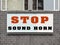Stop sound horn sign on a brick wall