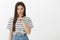 Stop talking, shut up. Portrait of angry outraged young european woman with brown hair and striped t-shirt, frowning