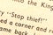 Stop thief! Single text line focus, words in an old book dramatic macro extreme closeup Literature thievery, burglary, robbery